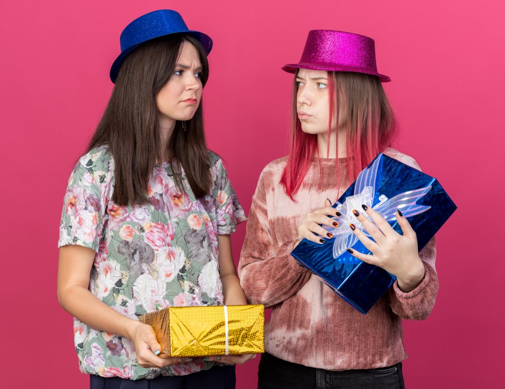 unpleased-girls-wearing-party-hat-holding-gift-boxes-look-at-each-other-isolated-on-pink-wall.jpg unpleased-girls-wearing-party-hat-holding-gift-boxes-look-at-each-other-isolated-on-pink-wall.jpg