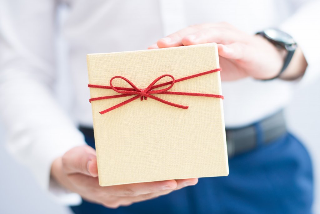 подарок коллегам на Новый год closeup-man-holding-gift-box-min.jpg